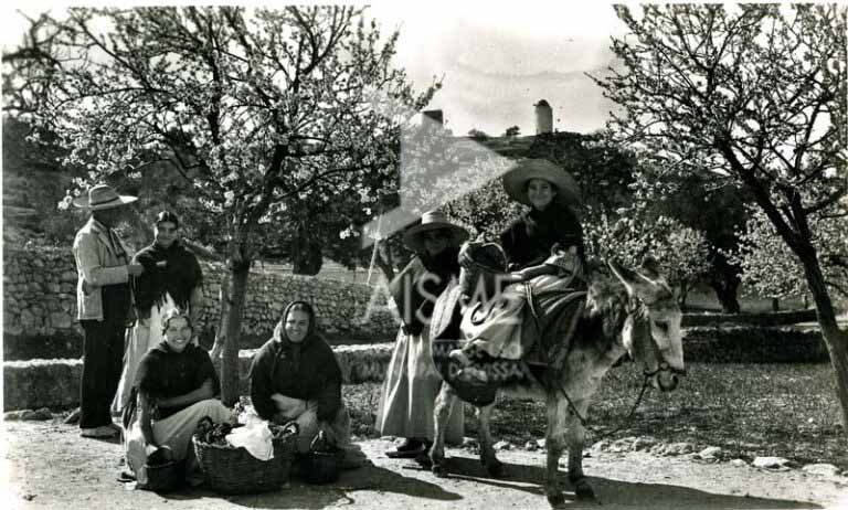 Payeses y payesas delante de los almendros de Puig des Molins.